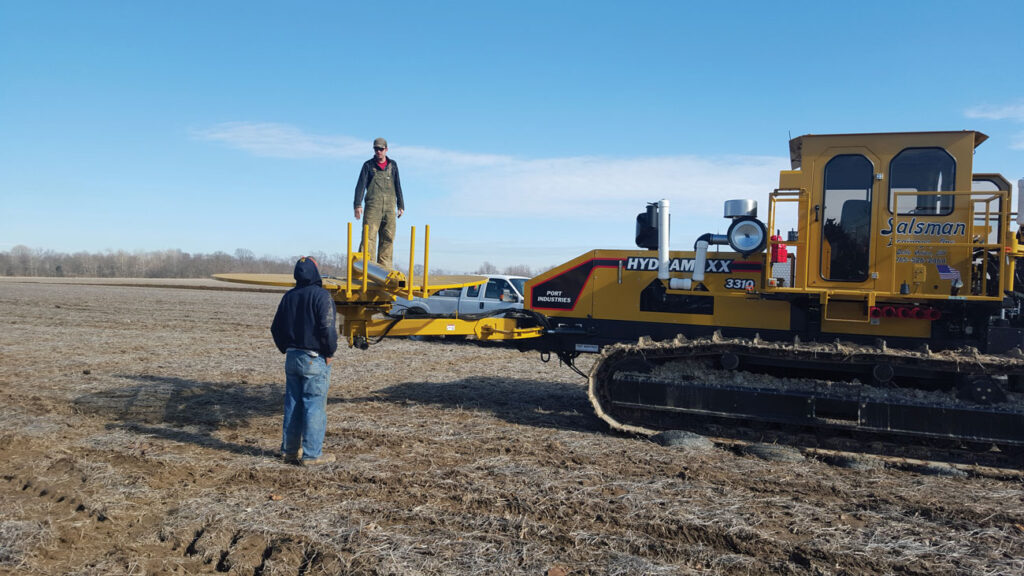 Men installing pipe in field