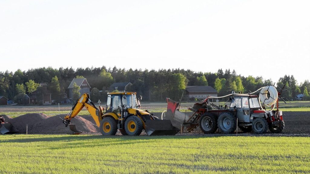 2 construction vehicles in field