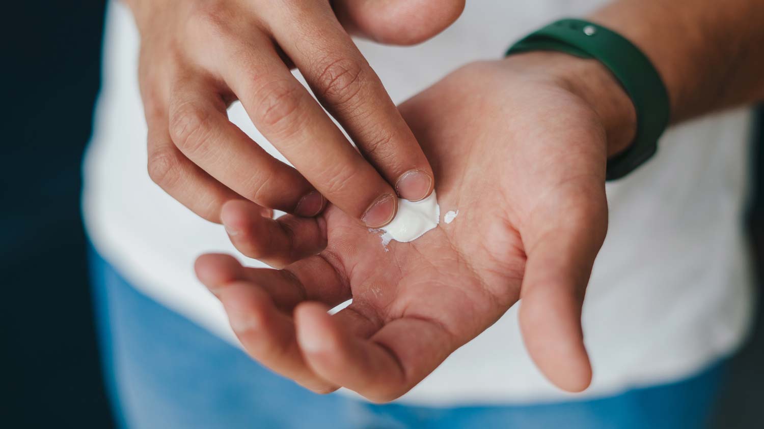 Man moistening hands with lotion